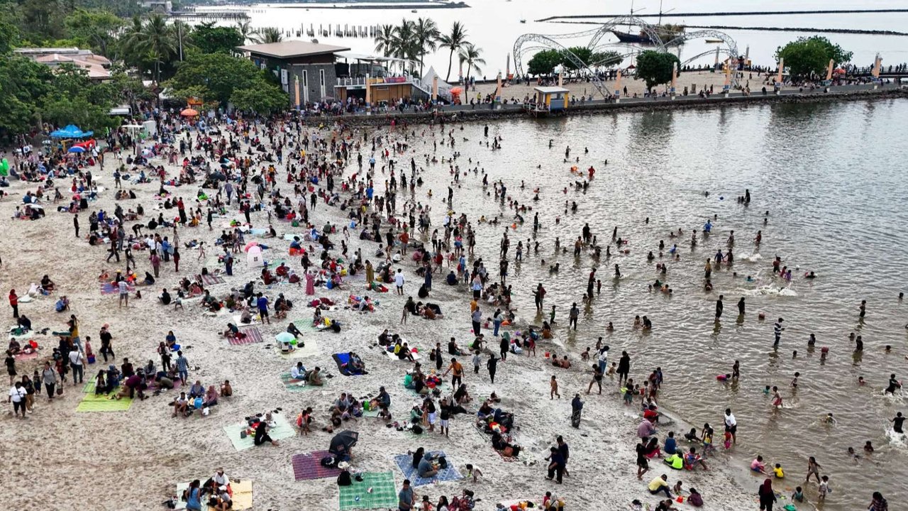 Sejumlah warga berwisata di Pantai Ancol Taman Impian, Jakarta, pada Selasa (1/4/2025) atau hari kedua libur Lebaran 2025. Pantai Ancol Taman Impian, Jakarta, menjadi salah satu destinasi wisata favorit warga saat libur Lebaran.