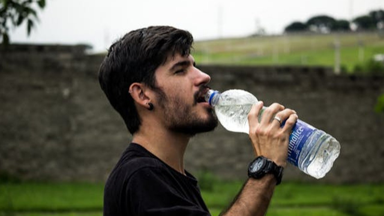 Ilustrasi Pria yang sedang Meminum Air dari Botol Plastik