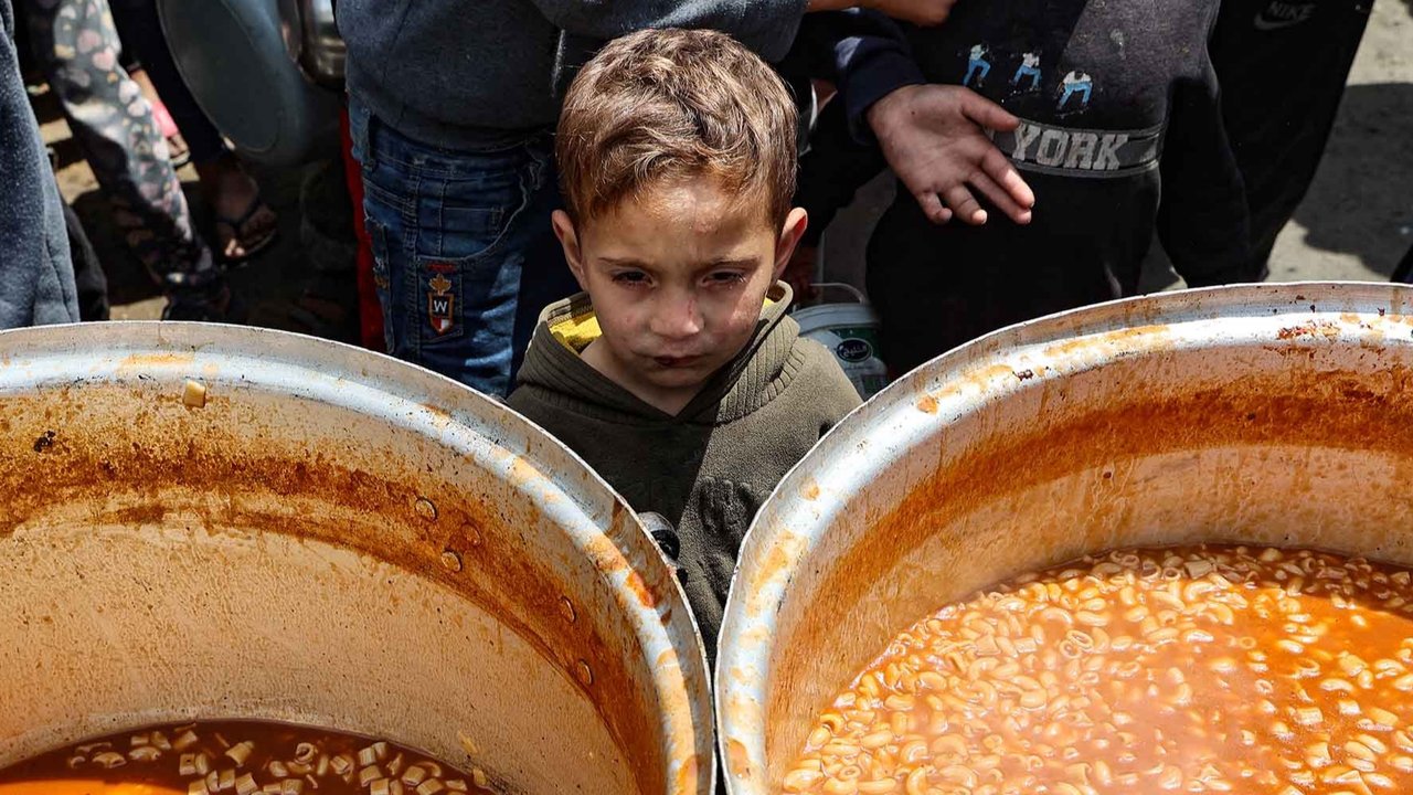Anak-anak  Palestina antri mendapatkan makanan di kamp pengungsi Nuseirat di Jalur Gaza bagian tengah, Sabtu (12/04/2025).