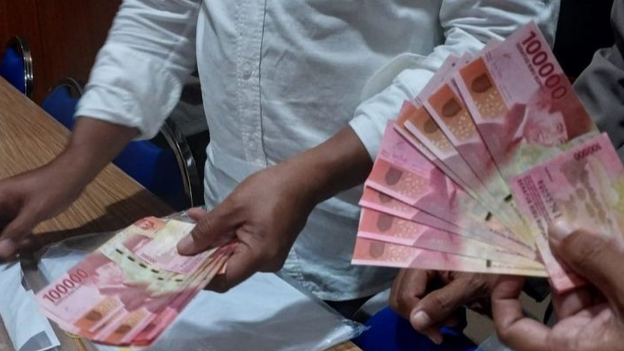 Petugas merapikan uang palsu saat rilis pengungkap penyebaran uang palsu di Gedung Lobby Bareskrime Mabes Polri, Jakarta, Kamis (23/9/2021). Bareskrim Polri mengungkap kasus tindak pidana pem