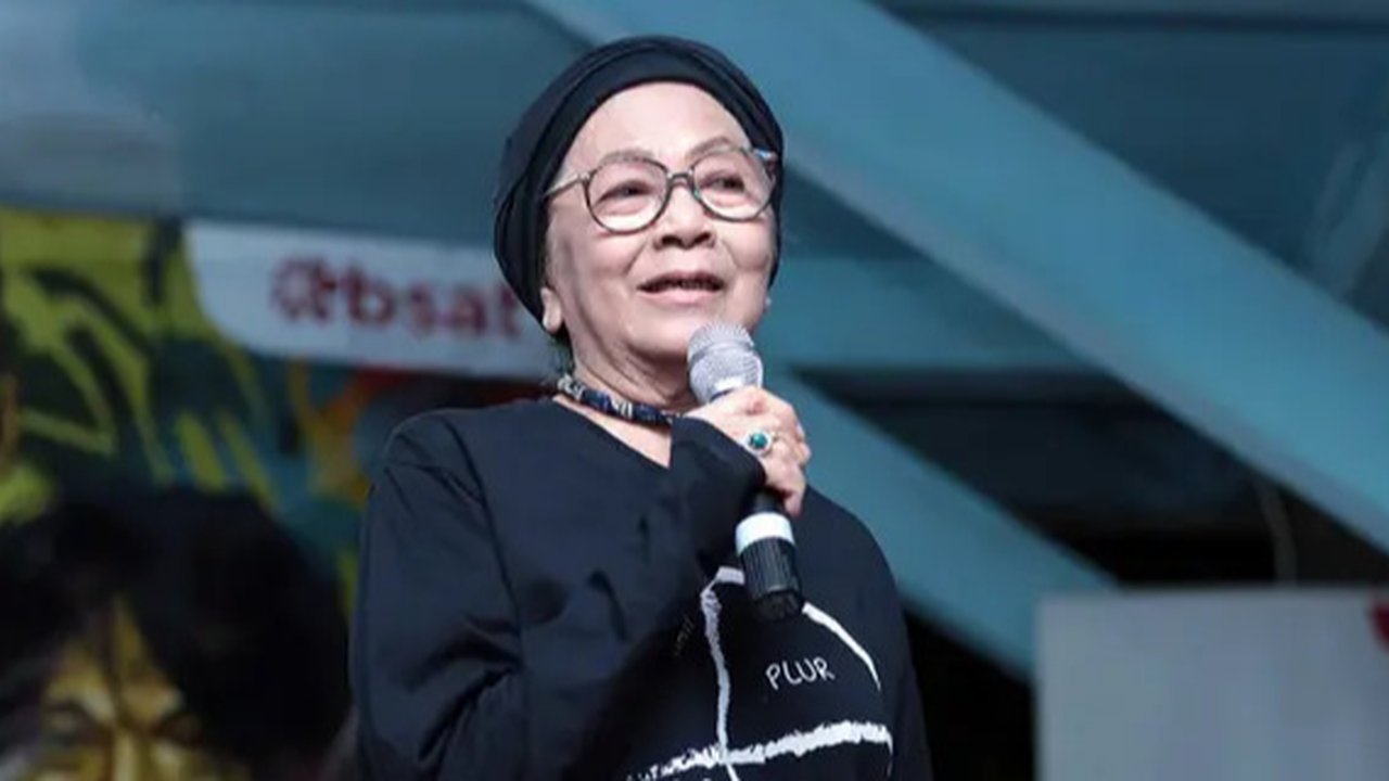 Bunda Iffet (kiri) saat memotong tumpeng pada acara ulang tahun suaminya markas slank, jakarta, senin (18/01/2016). Bimbim Slank juga membuat sebuah band keluarga pada perayaan ini yang berna