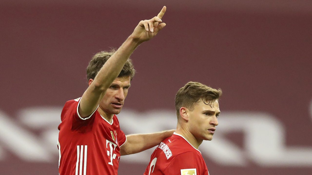Striker Bayern Munich, Thomas Mueller (kiri) merayakan gol kedua timnya yang dicetak Joshua Kimmich (kanan) dalam laga lanjutan Liga Jerman 2020/2021 pekan ke-30 di Allianz Arena, Munich, Selasa (20/4/2021). Bayern Munich menang 2-0 atas Leverkusen. (AP/Matthias Schrader/Pool)