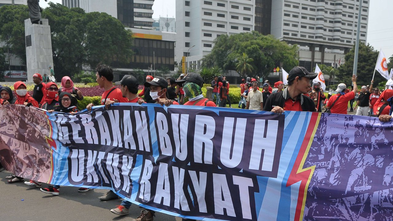 Massa aksi Hari Buruh membawa spanduk saat memperingati Hari Buruh Internasional di Jakarta, Senin (1/5). Dalam aksinya para buruh meminta sistem kerja kontrak dan upah rendah dihapus. (Liputan6.com/Helmi Afandi)
