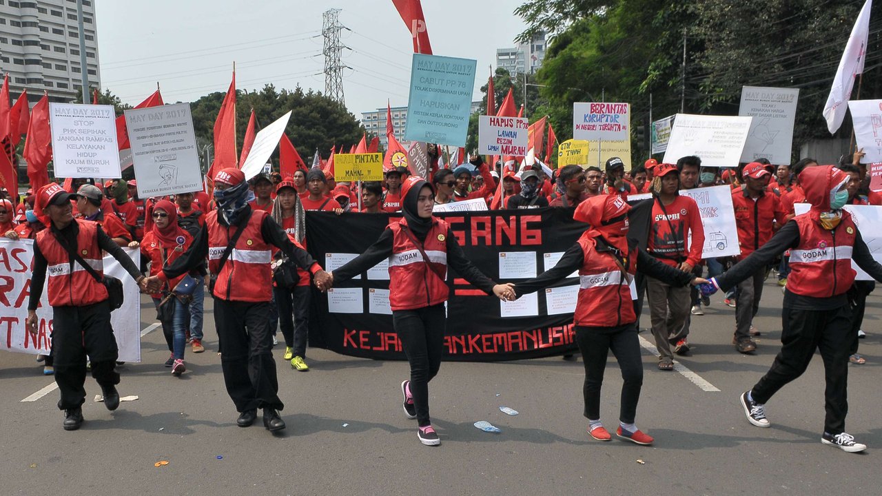 Massa buruh berjalan menuju Istana Negara saat aksi Hari Buruh di Jakarta, Senin (1/5). Dalam aksinya para buruh meminta sistem kerja kontrak dan upah rendah dihapus. (Liputan6.com/Helmi Afandi)