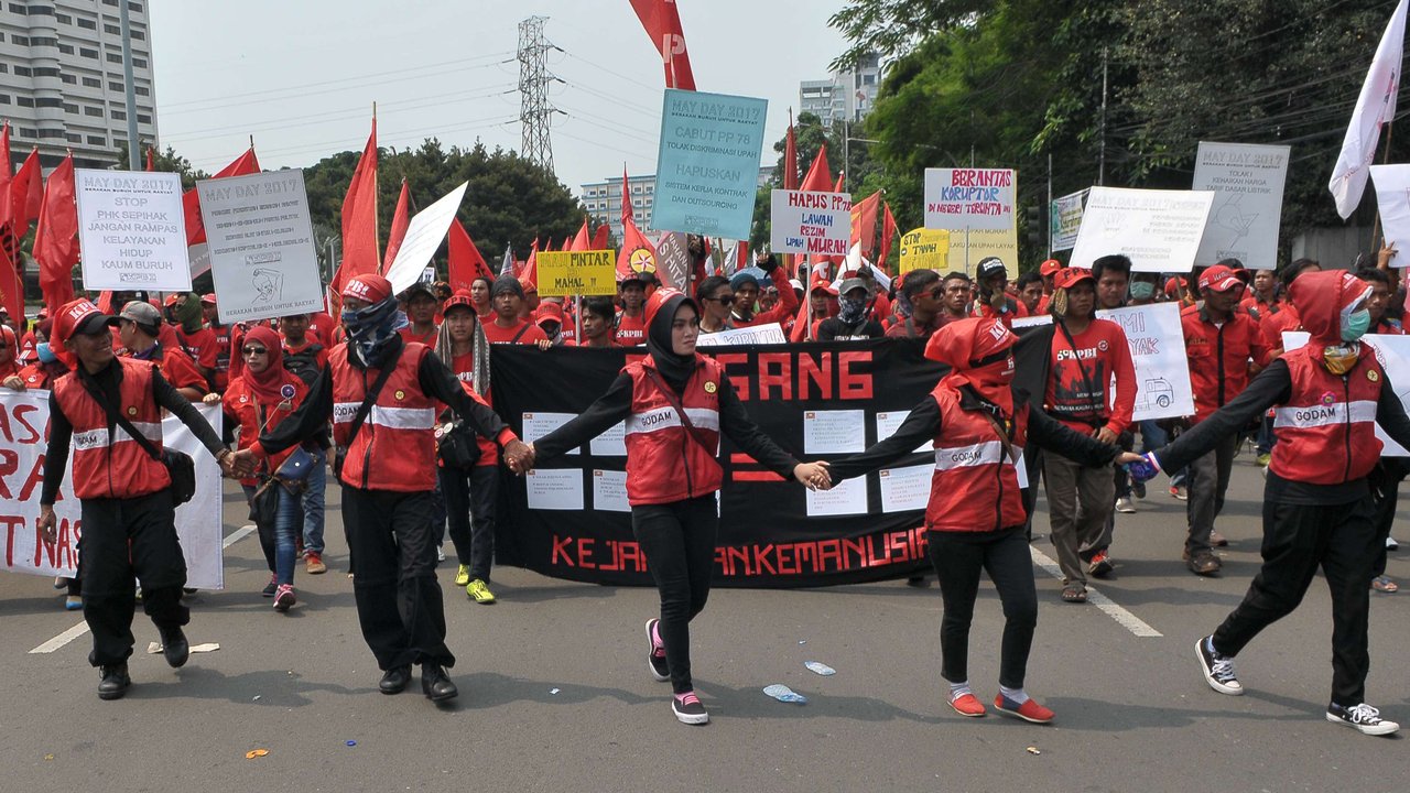 Massa buruh berjalan menuju Istana Negara saat aksi Hari Buruh di Jakarta, Senin (1/5). Dalam aksinya para buruh meminta sistem kerja kontrak dan upah rendah dihapus. (Liputan6.com/Helmi Afandi)