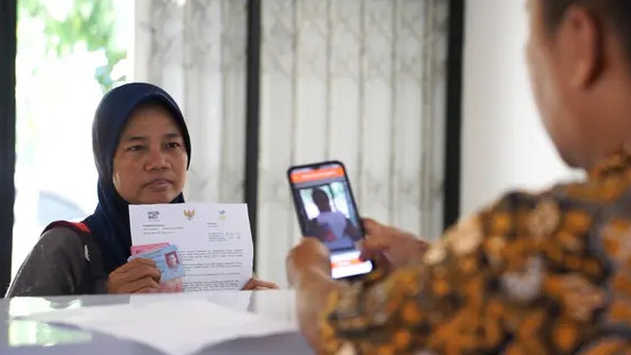 Warga menunjukkan KKS saat Penyaluran Bantuan Sosial PKH dan BPNT di Depok, Jawa Barat, Selasa (12/2).1000 orang warga Depok, Keluarga Penerima Manfaat (KPM) Program Keluarga Harapan (PKH) me