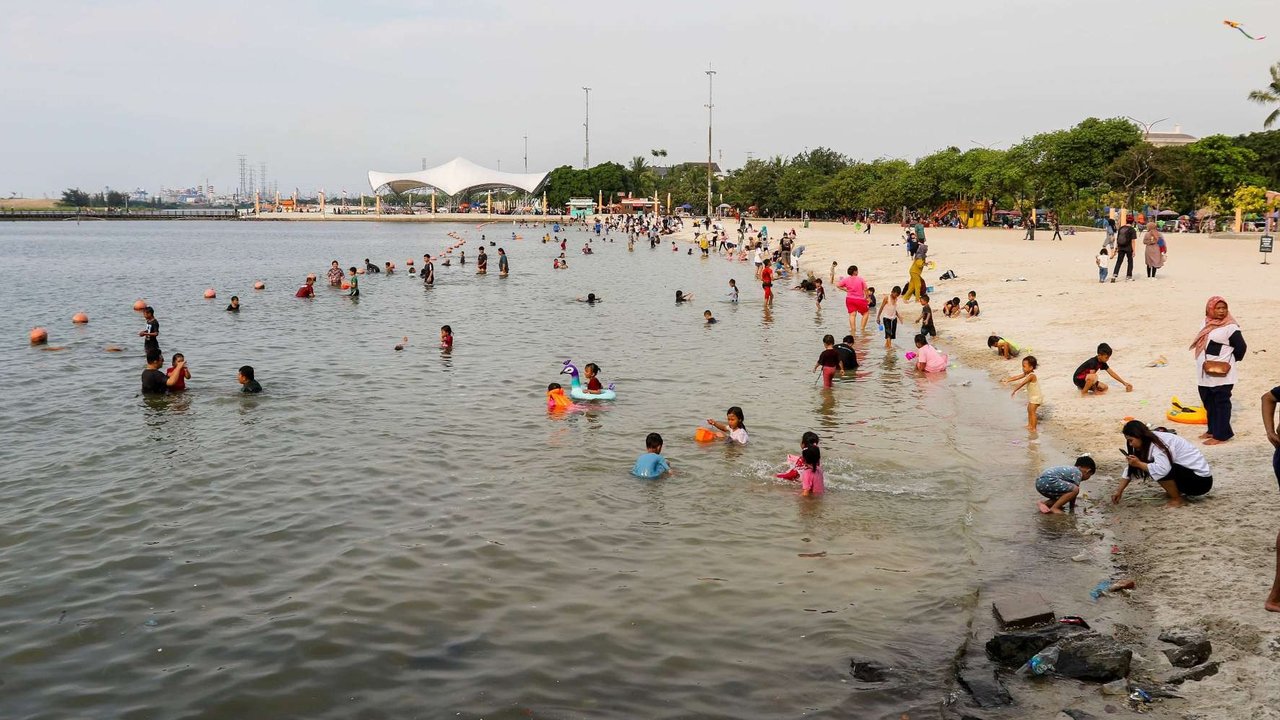 Sejumlah pengunjung menghabiskan libur panjang perayaan Waisak di Pantai Lagoon, Taman Impian Jaya Ancol, Jakarta, Selasa (13/5/2025).