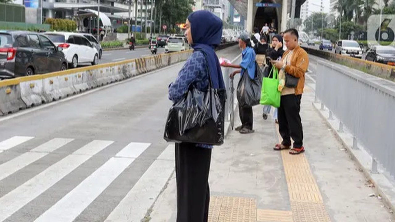 Sejumlah pekerja mengenakan masker melintas saat jam pulang kerja di kawasan Sudirman, Jakarta, Rabu (16/8/2023). (Liputan6.com/Angga Yuniar)