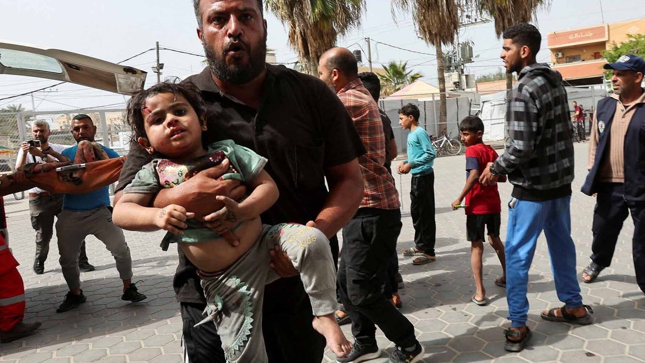 Warga menggendong seorang anak yang terluka ke rumah sakit Al-Aqsa Martyrs setelah serangan Israel di Deir Al-Balah, Jalur Gaza bagian tengah, (17/05/2025).