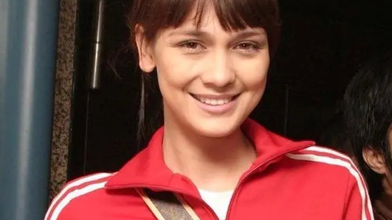 Mengenakan jaket training merah, Luna Maya saat itu masih terlihat muda. Ia pun tampil natural dengan memerlihatkan wajah blasteran yang memesona. Dengan rambut pirang diikat ke belakang l