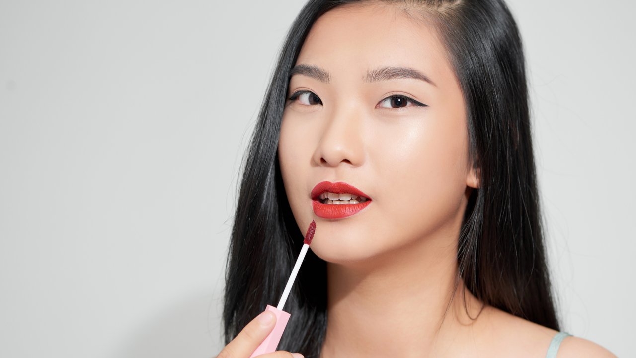 Ilustrasi perempuan menggunakan lip tint.