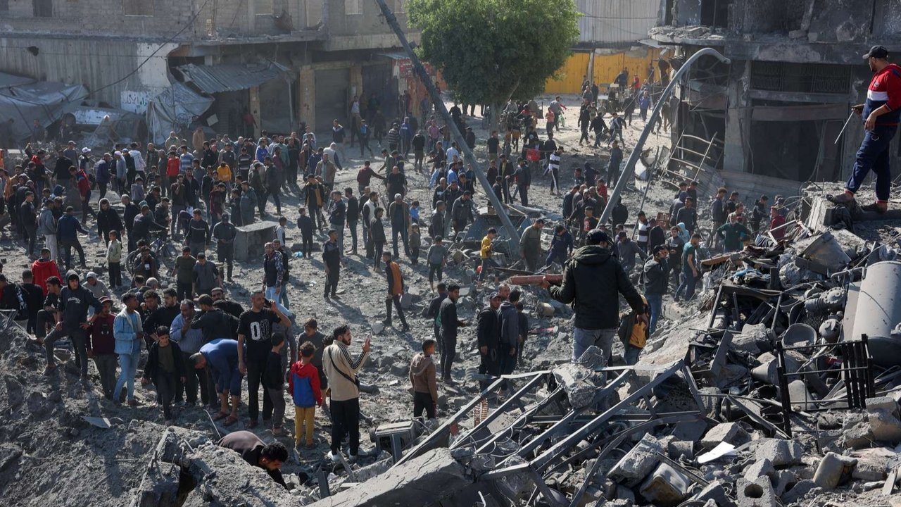 Sejumlah warga Palestina berkerumun di sekitar kawah menganga bekas serangan rudal Israel di lingkungan Zaytoun, Kota Gaza, Palestina, pada 13 April 2025.