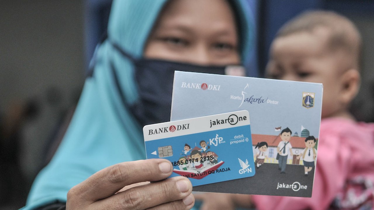 Orangtua dari anak penerima saat menunjukkan KJP yang baru diterima di kawasan Matraman, Jakarta, Selasa (24/11/2020). Penyaluran KJP plus tahap kedua ini menggunakan data baru berdasarkan pembaruan berkas warga penerima yang rampung pada bulan Oktober lalu. (merdeka.com/Iqbal S. Nugroho)