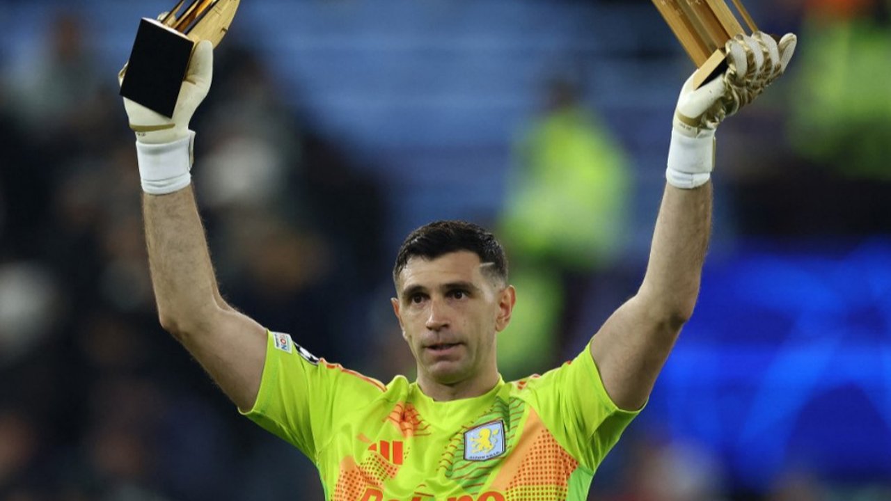 Kiper Aston Villa asal Argentina #23, Emiliano Martinez, memberikan penghargaan Golden Glove kepada para penggemar menjelang pertandingan Liga Champions UEFA antara Aston Villa dan Juventus di Villa Park di Birmingham, Inggris bagian tengah, Kamis dini hari WIB (28/11/2024). (Darren Staples/AFP)