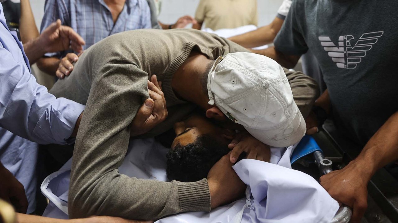 Keluarga  berduka di dekat jenazah warga Palestina yang tewas sehari sebelumnya akibat tembakan Israel saat antri mendapatkan bantuan pangan, di kamar mayat rumah sakit Al-Shifa di Kota Gaza, Rabu (18/06/2025).