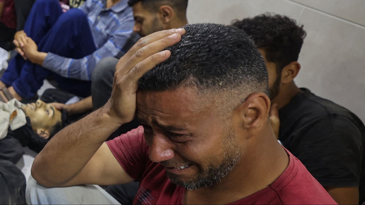 Warga Palestina duduk di sekitar jenazah keluarganya  yang tewas dalam tembakan Israel di titik distribusi bantuan pangan yang didirikan oleh Yayasan Kemanusiaan Gaza (GHF) di rumah sakit Al-Awda di kamp pengungsi Nuseirat di Jalur Gaza tengah, Palestina, Selasa (24/06/2025)