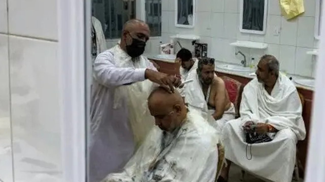 Jemaah haji 2025 menunggu di luar tempat pangkas rambut untuk dipotong rambut di Mina pada 6 Juni 2025. (HAZEM BADER/AFP)