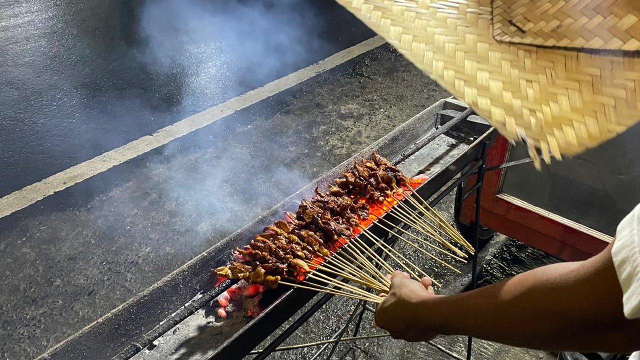 Ilustrasi Tukang Sate Membakar Daging Sate