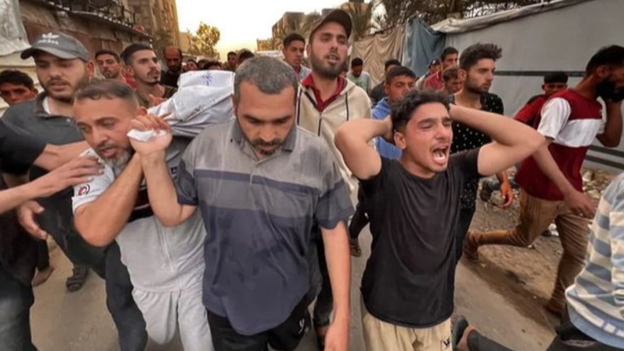 Warga Gaza memeriksa kerusakan di lokasi serangan Israel terhadap kamp tenda yang menampung pengungsi, di Khan Younis, Jalur Gaza selatan, Palestina, Minggu (18/05/2025)