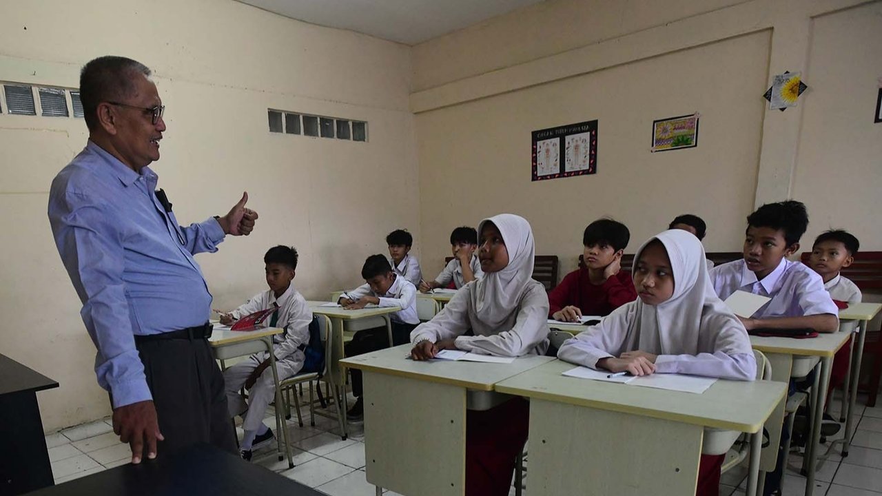 Murid tingkat SMP  dalam program Rintisan Sekolah Swasta Gratis belajar dalam kelas saat kegiatan MPLS (Masa Pengenalan Lingkungan Sekolah) di SMP Tarbiyah Islamiyah, Depok, Jawa Barat, Senin (14/07/2025).