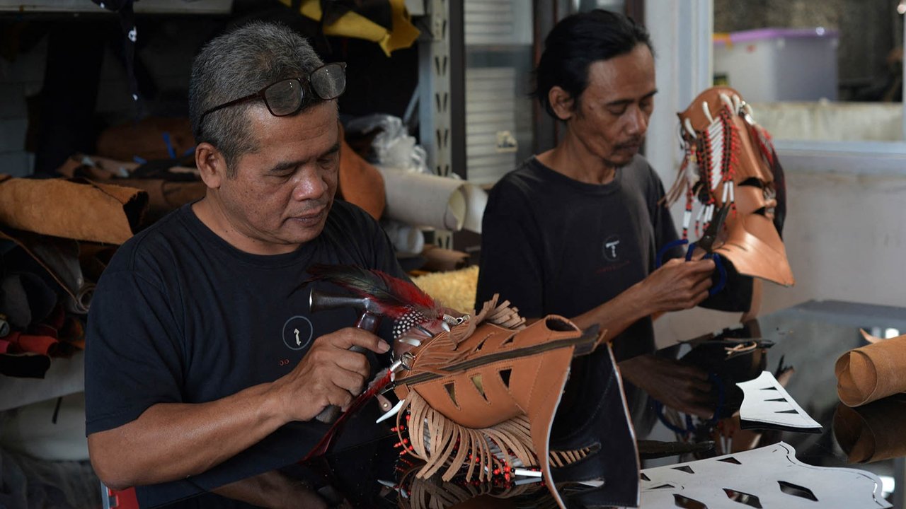 Perajin sedang mengerjakan sepasang sepatu bot kulit untuk pasar AS di bengkel Tegep Boots di Bandung, Jawa Barat, Selasa (15/07/2025).