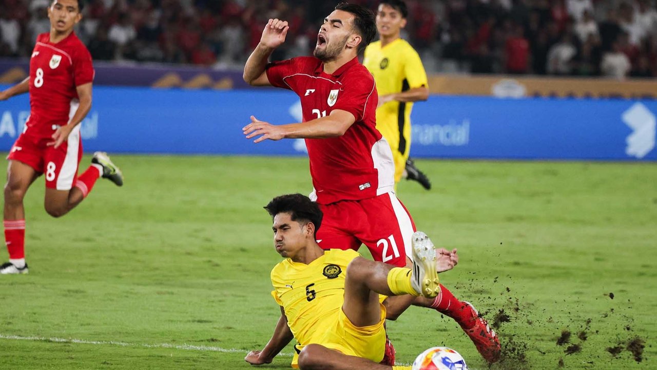Pesepak bola Timnas U-23 Indonesia Jens Raven terjatuh saat berebut bola dengan pesepak bola Timnas U-23 Malaysia Muhammad Shafizan dalam pertandingan penyisihan Grup A Piala AFF U-23 2025 di Stadion Utama Gelora Bung Karno (SUGBK), Senayan, Jakarta, Senin (21/7/2025).