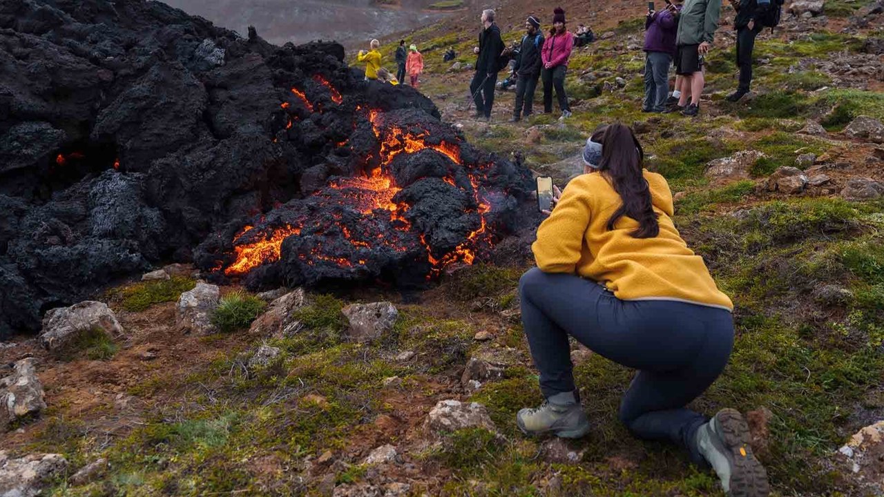 Wisatawan mengambil foto lava cair, setelah letusan gunung berapi di Semenanjung Reykjanes, Islandia, Rabu, (23/07/2025).