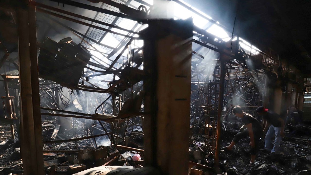 Sejumlah pedagang mengais puing dan sisa barang dagangan yang hangus terbakar di Pasar Taman Puring, Jakarta Selatan, Selasa (29/7/2025).