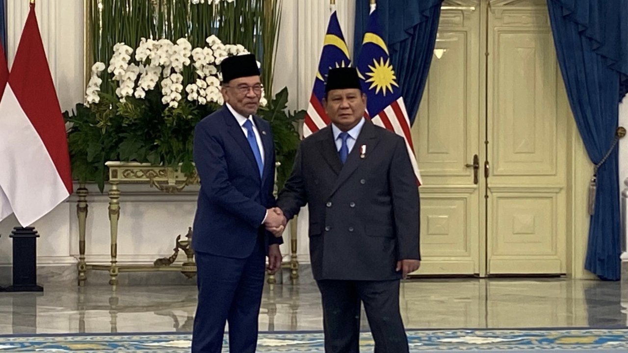 Presiden Indonesia Prabowo Subianto berjalan bersama Perdana Menteri Malaysia Anwar Ibrahim saat pertemuan mereka di Istana Merdeka,  Jakarta, Selasa (29/07/2025).