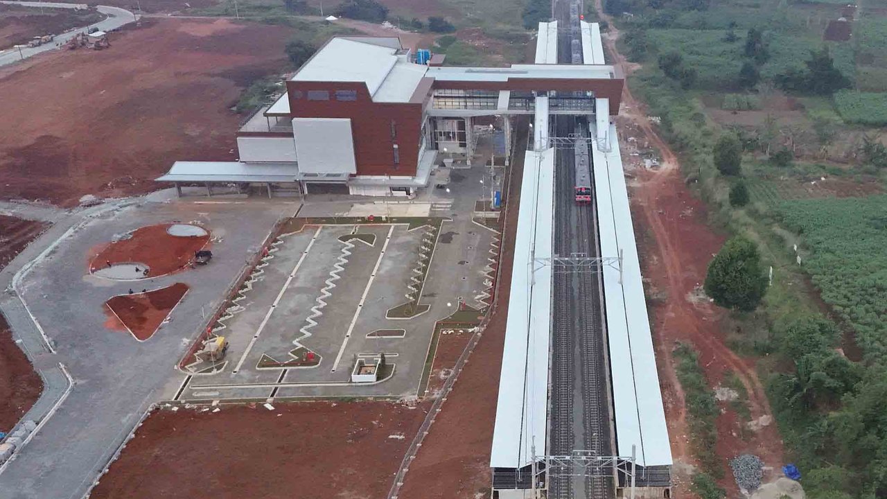 Foto udara rangkaian kereta rel listrik (KRL) Commuterline melintas di samping proyek pembangunan Stasiun Jatake, Pagedangan, Kabupaten Tangerang, Banten, Selasa (29/7/2025).