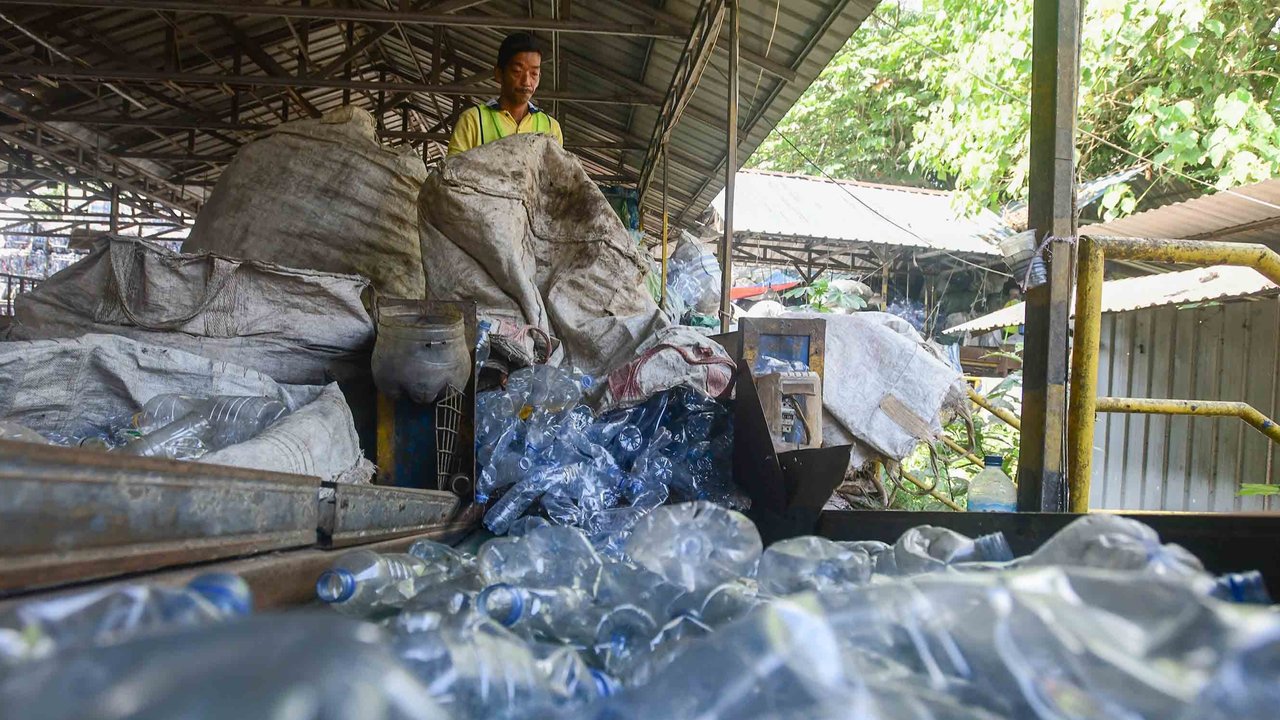 Pekerja mengolah sampah botol plastik menjadi cacahan plastik sebagai bahan biji plastik di Koperasi Pemulung Berdaya atau Recycle Business Unit (RBU) Tangerang Selatan, Tangerang, Banten, Rabu (30/07/2025).