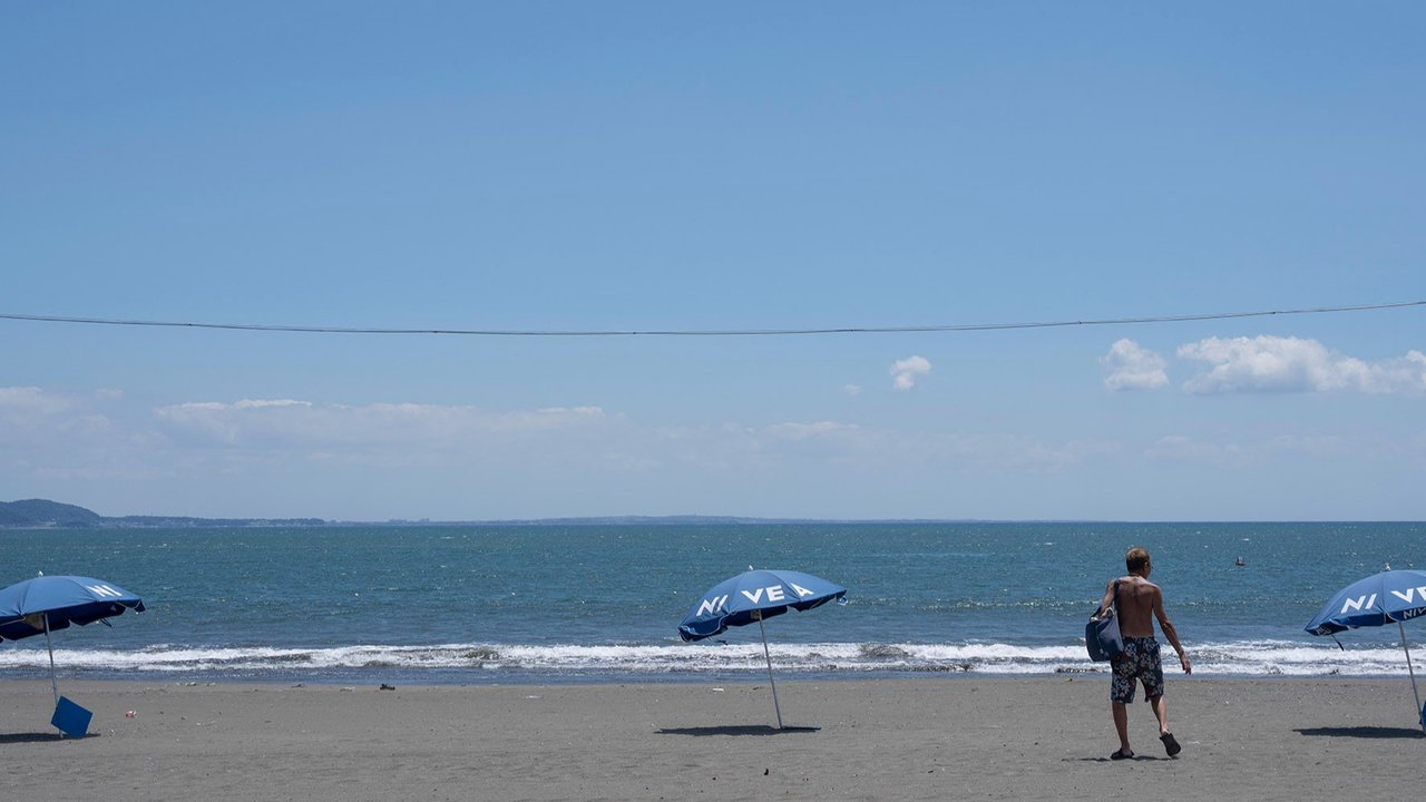 Seorang pria berjalan di pantai yang sepi akibat peringatan tsunami di kota Fujisawa, Prefektur Kanagawa, Jepang, Rabu (30/07/2025).