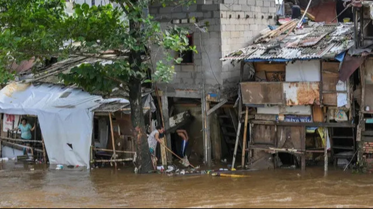 Warga beraktifitas saat banjir merendam pemukiman di Jalan Pirus, Kelurahan Bidara Cina, Jatinegara, Jakarta Timur, Minggu (06/07/2025).