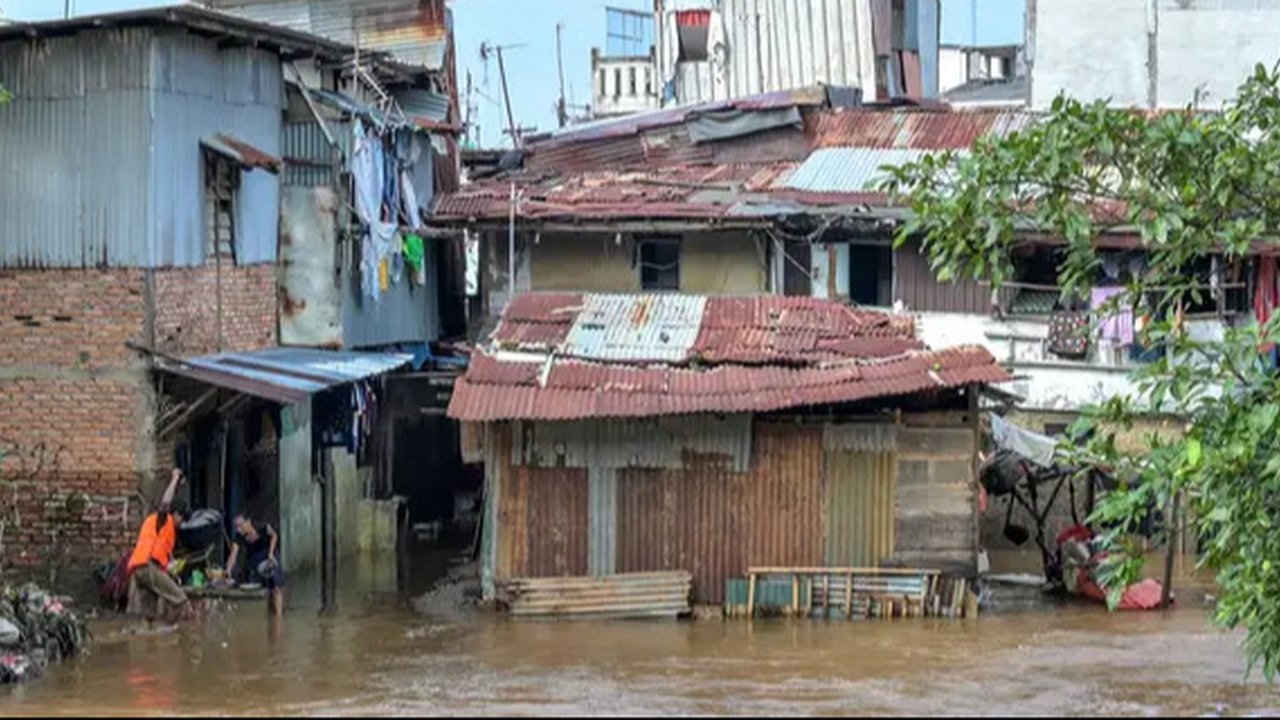 Tingginya intensitas hujan yang terjadi pada Minggu (6/7/2025) sore dan luapan air sungai terdekat menyebabkan banjir kembali melanda sejumlah wilayah Jakarta pada Senin pagi (7/7/2025). (BAY ISMOYO/AFP)