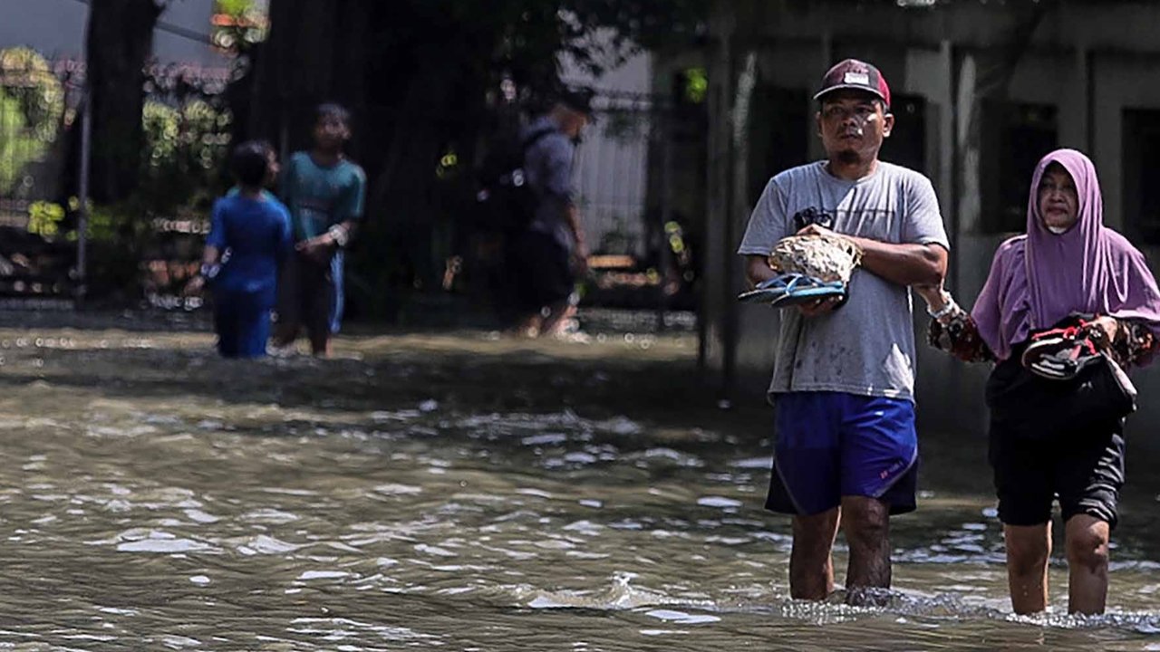 Aktivitas warga saat banjir merendam pemukiman di kawasan Kampung Makasar, Jakarta Timur, Senin (7/7/2025).