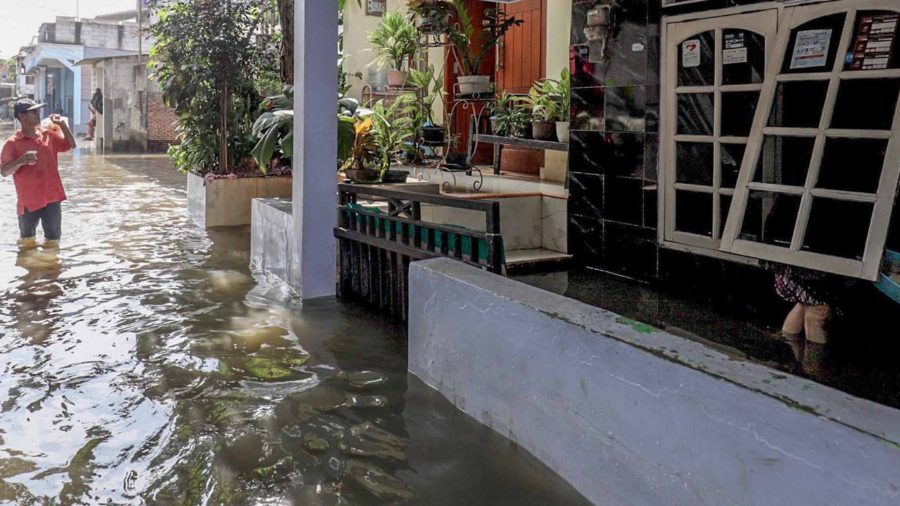 Aktivitas warga saat banjir merendam pemukiman di kawasan Kampung Makasar, Jakarta Timur, Senin (7/7/2025).