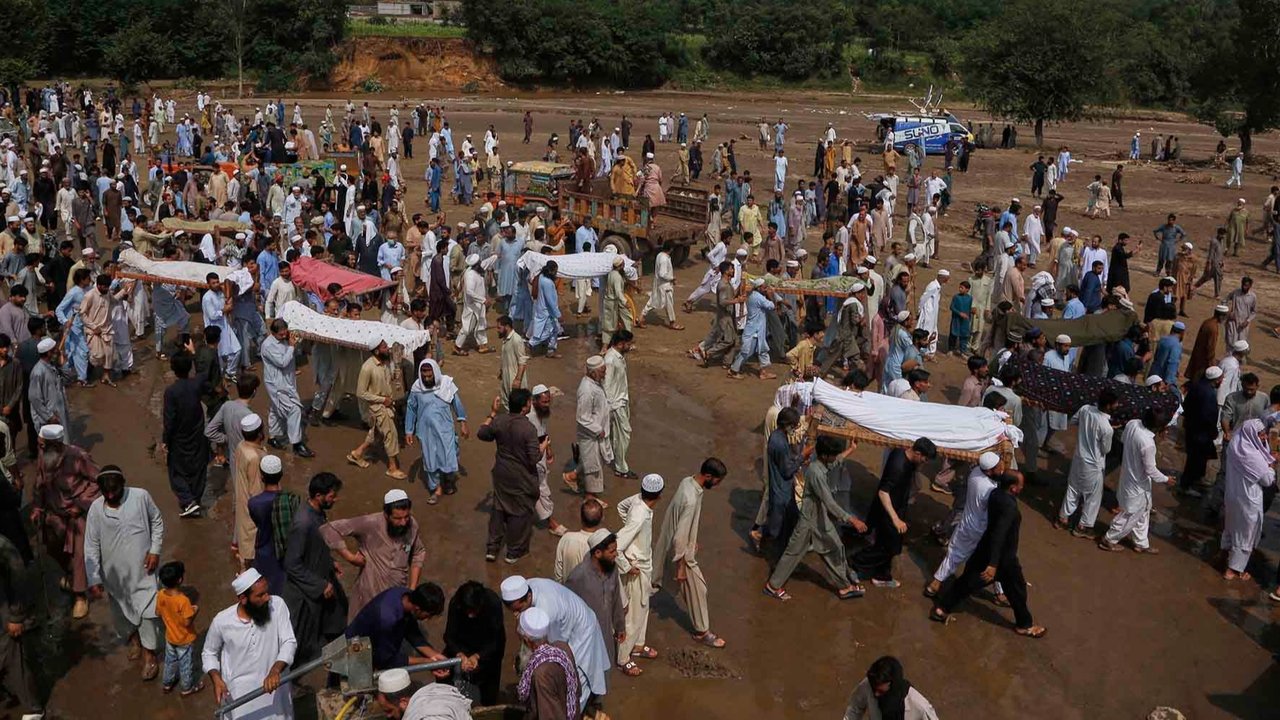 Warga membawa jenazah korban banjir bandang setelah salat jenazah di sebuah desa dekat Pir Baba, distrik Buner, di barat laut Pakistan,  Sabtu (16/08/2025).
