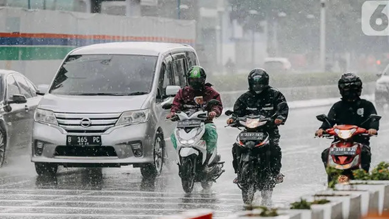Pengendara motor menggunakan jas hujan saat hujan deras mengguyur kawasan Jalan Thamrin, Jakarta, Selasa (31/5/2022). Potensi cuaca ekstrem di sejumlah wilayah di Indonesia pada hari ini d