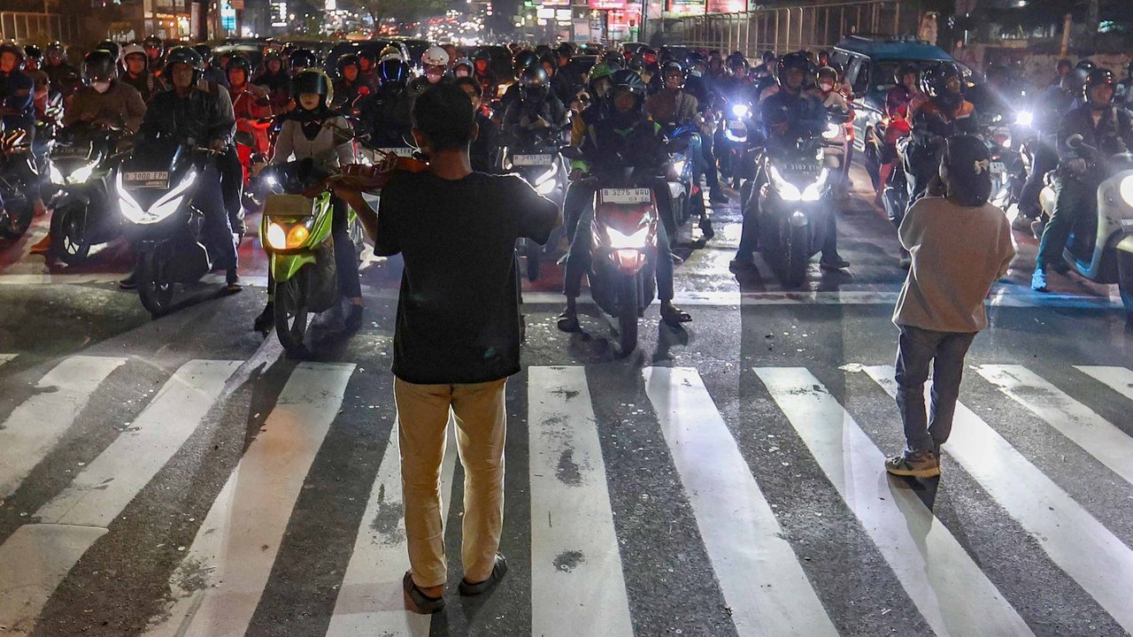 Pengamen Kris Violist dan istrinya di perempatan Juanda, Depok, jumat malam (22/08/2025).