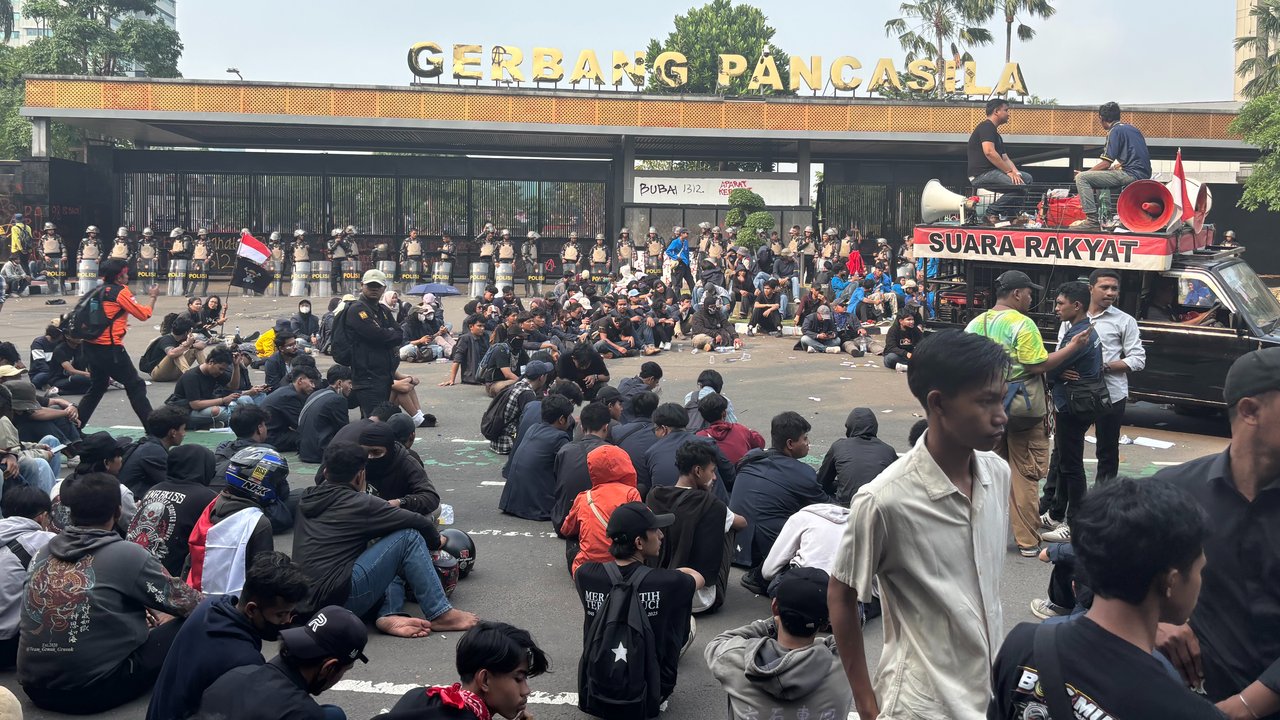 Berbaju Hitam Duduk di Tengah Jalan, Potret Pendemo 'Lesehan' di gerbang Pancasila DPR Usai Dipukul Mundur Aparat