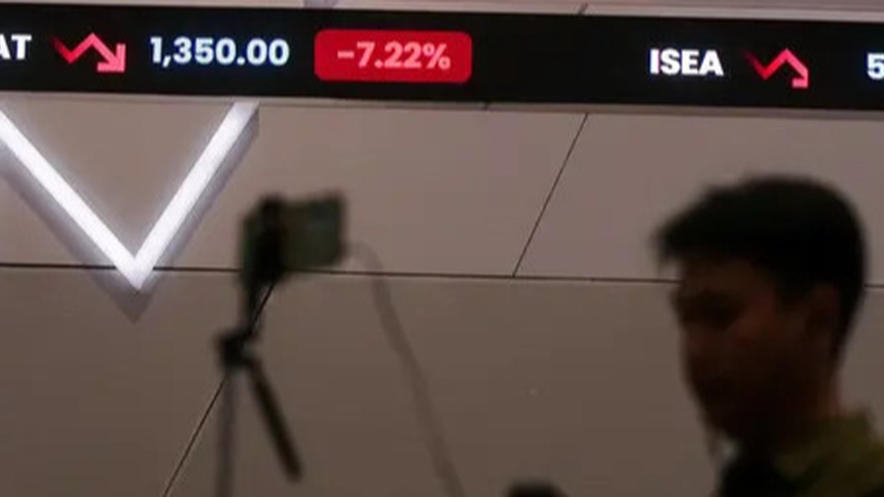 Karyawan melintasi layar yang menampilkan Indeks Harga Saham Gabungan (IHSG) saat acara Penutupan Perdagangan Bursa Efek Indonesia Tahun 2022 di Jakarta, Jumat (30/12/2022). PT Bursa Efek Ind