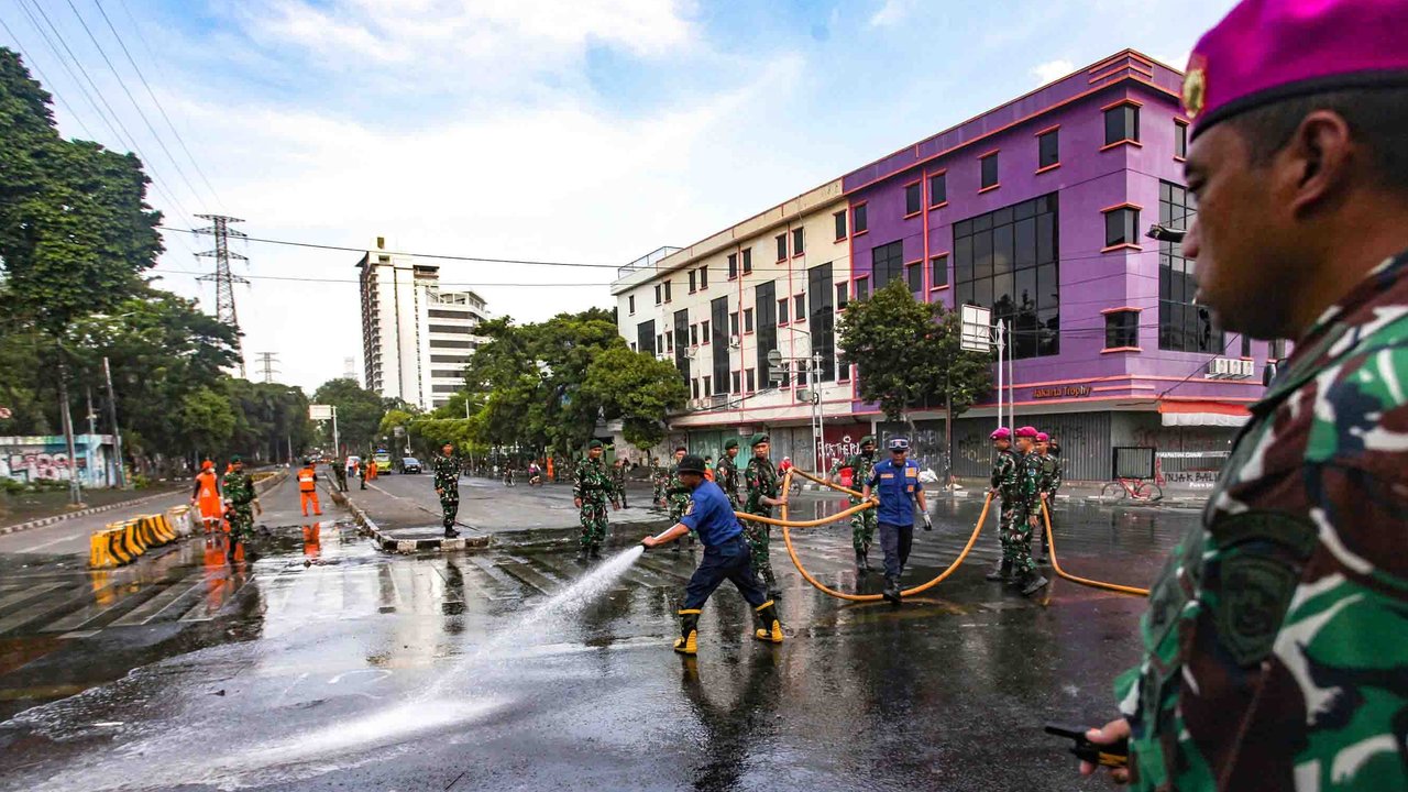 Personel TNI gabungan Kostrad dan Marinir membersihkan material sisa unjuk rasa di kawasan Mako Brimob, Kwitang, Senen, Jakarta, Minggu (31/8/2025).