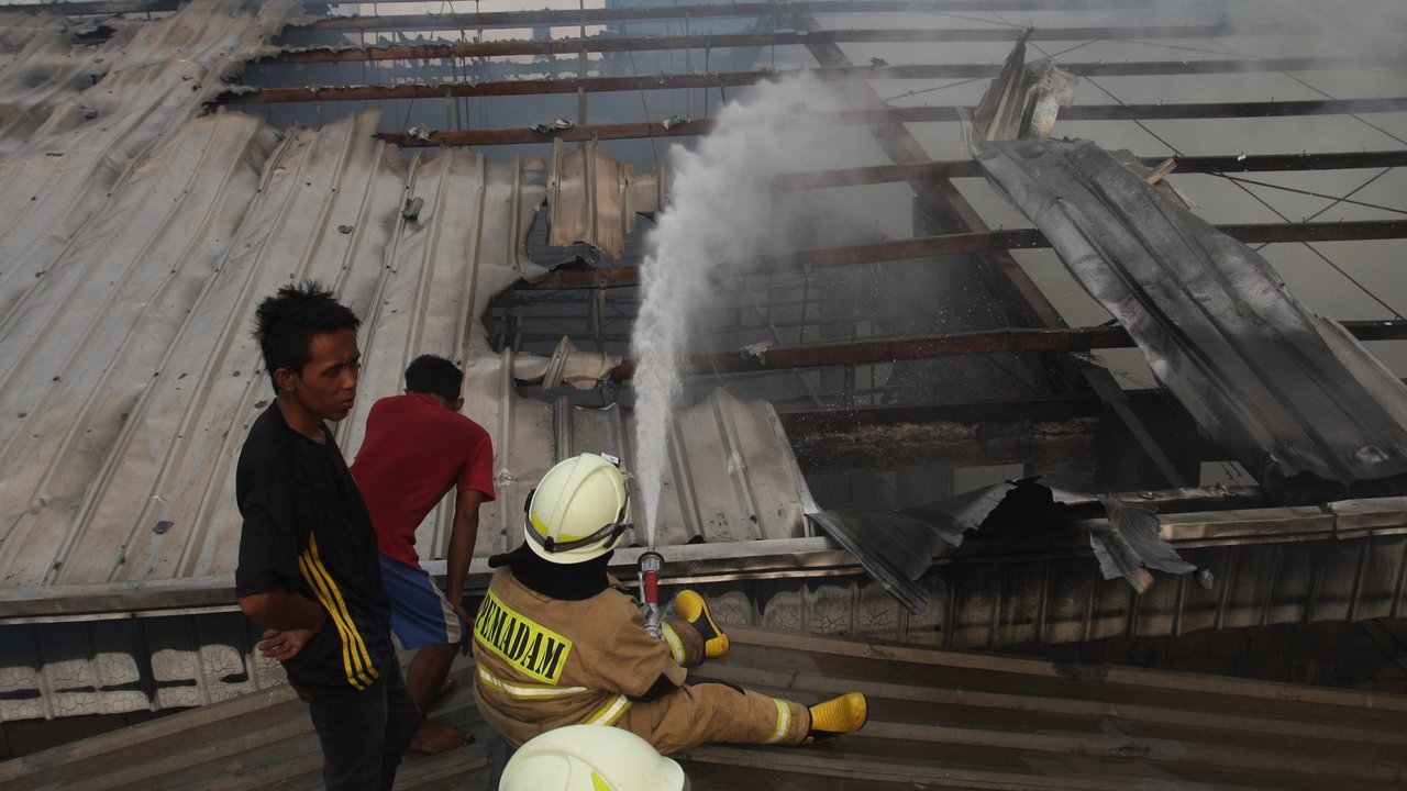 Petugas Gulkarmat berusaha memadamkan api yang membakar gudang distributor wallpaper di Muara Baru, Penjaringan, Jakarta Utara, Jumat, (15/11/2024).