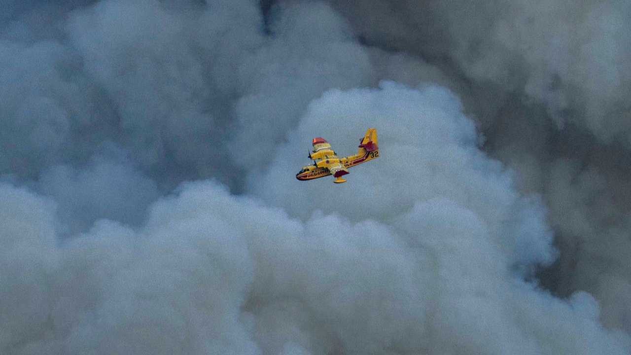Pesawat Canadair CL-415 milik keamanan sipil Prancis terbang di atas kebakaran hutan di Jonquières, Prancis barat daya, Selasa (05/08/2025) waktu setempat.