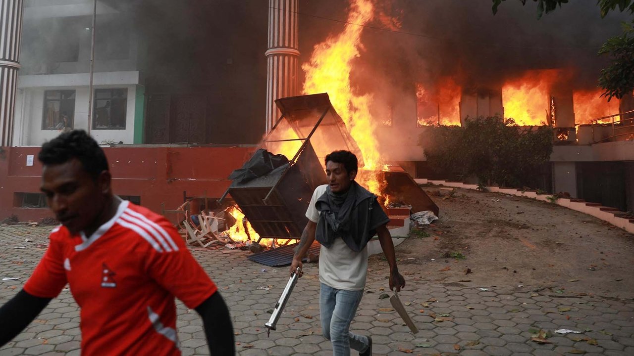 Para demonstran berkumpul di luar kantor Partai Kongres Nepal yang terbakar dalam aksi protes untuk mengecam tindakan keras polisi terhadap demonstran di Kathmandu, Selasa (9/09/2025).