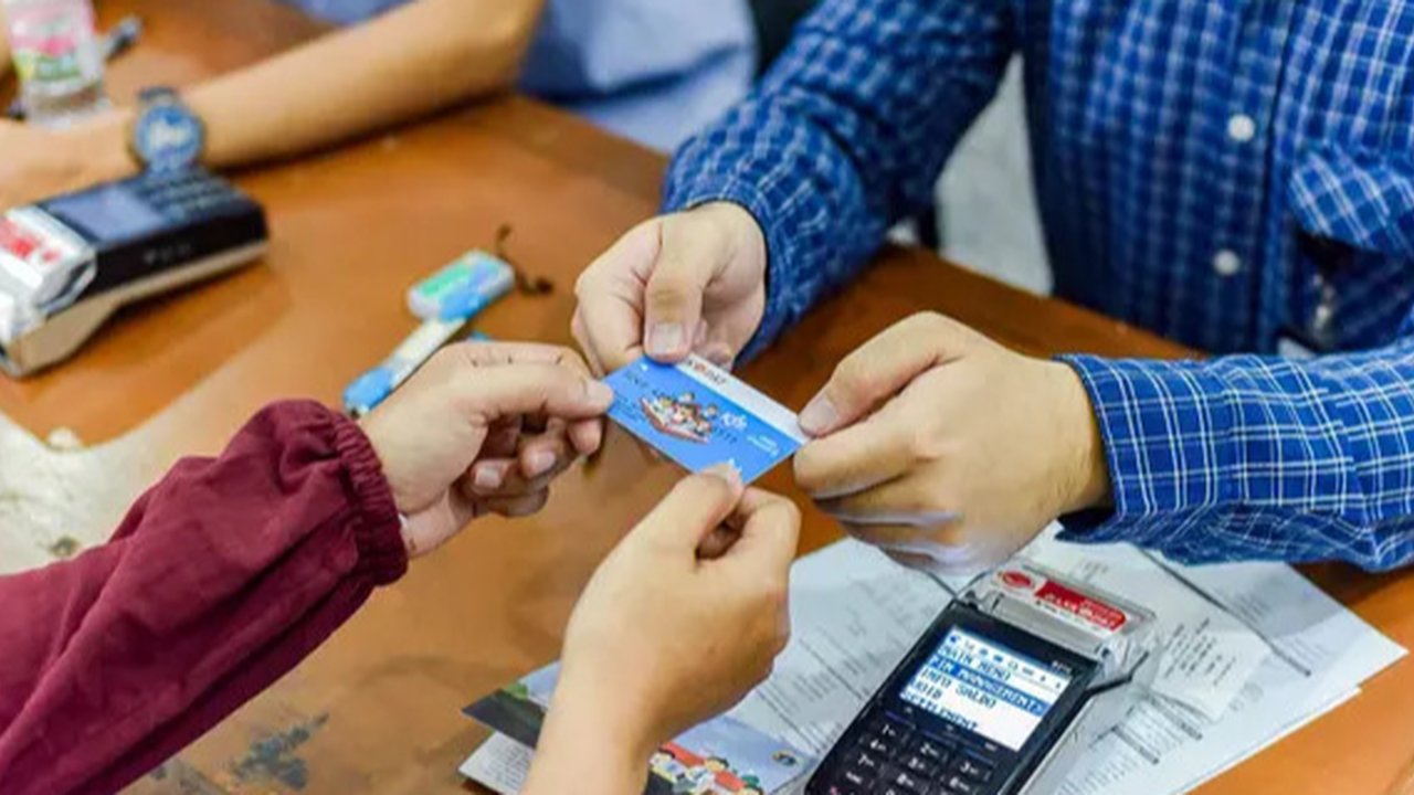 Orangtua dari anak penerima saat menunjukkan KJP yang baru diterima di kawasan Matraman, Jakarta, Selasa (24/11/2020). Penyaluran KJP plus tahap kedua ini menggunakan data baru berdasarkan pe