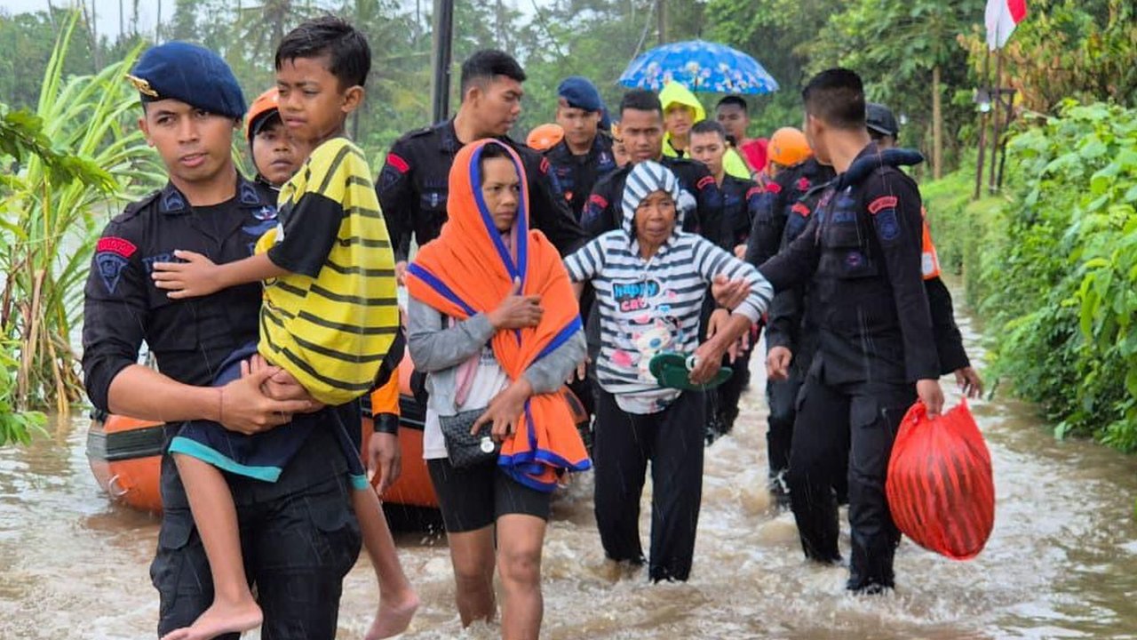 Anggota Brimob Polda Bali mengevakuasi warga saat banjir besar menerjang Pulau Bali, Rabu (10/9/2025)