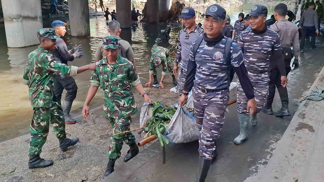 Tim Satgas Bencana Banjir Pangkalan TNI AL (Lanal) Denpasar bersama petugas gabungan dari unsur TNI AD dan kepolisian membersihkan area tergenang lumpur dan dipenuhi sampah sisa banjir di wilayah Pasar Badung, Denpasar, Sabtu (13/09/2026).