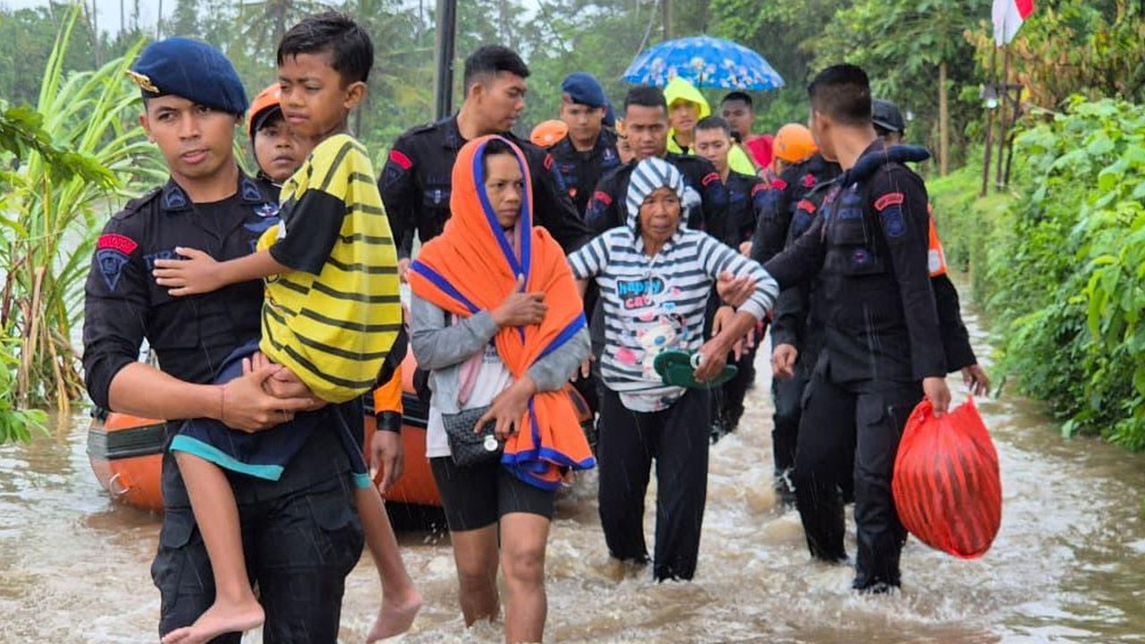 Anggota Brimob Polda Bali mengevakuasi warga saat banjir besar menerjang Pulau Bali, Rabu (10/9/2025)