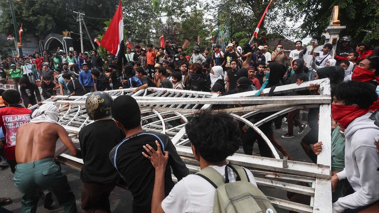 Seorang polisi melarikan diri dari para pengunjuk rasa yang marah saat demonstrasi di depan Mapolda  Bali di Denpasar, Bali, Indonesia, Sabtu (30/08/2025).